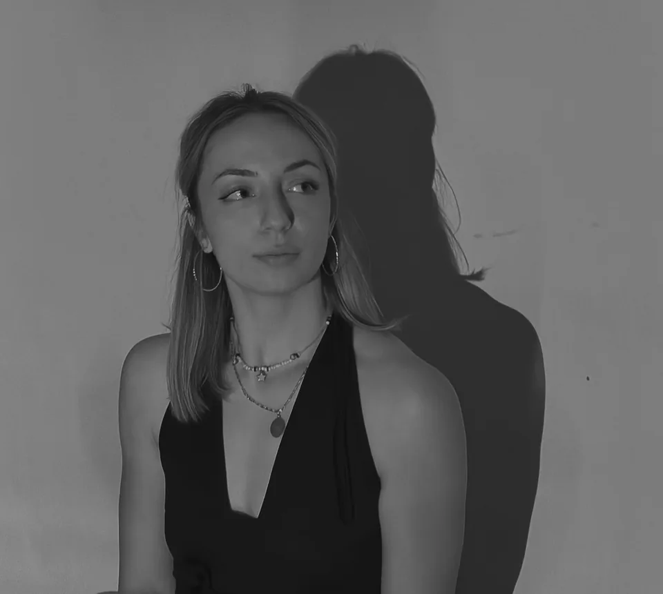 Danica Antić, photographed against a plain wall with her shadow beside her.